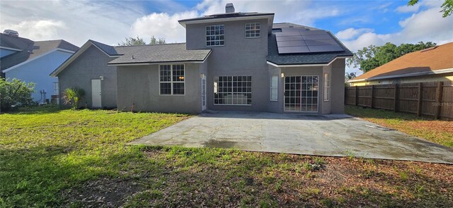 8612 Valley Ridge Ct, Orlando, FL 32818 - back of property featuring stucco siding, a patio area, roof mounted solar panels, and a shingled roof