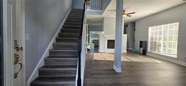 8612 Valley Ridge Ct, Orlando, FL 32818 - stairs with wood finished floors, a ceiling fan, baseboards, and a glass covered fireplace