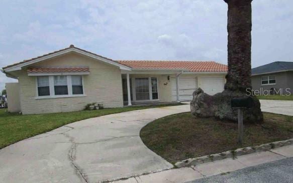 5500 Leeward Ln, New Port Richey, FL 34652 - single story home featuring an attached garage, a tiled roof, concrete driveway, and a front lawn