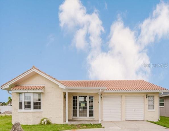 5500 Leeward Ln, New Port Richey, FL 34652 - view of front of house featuring a tiled roof, an attached garage, driveway, and a front lawn