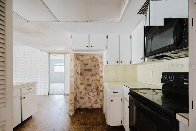 5500 Leeward Ln, New Port Richey, FL 34652 - kitchen with black appliances, white cabinetry, light countertops, and backsplash