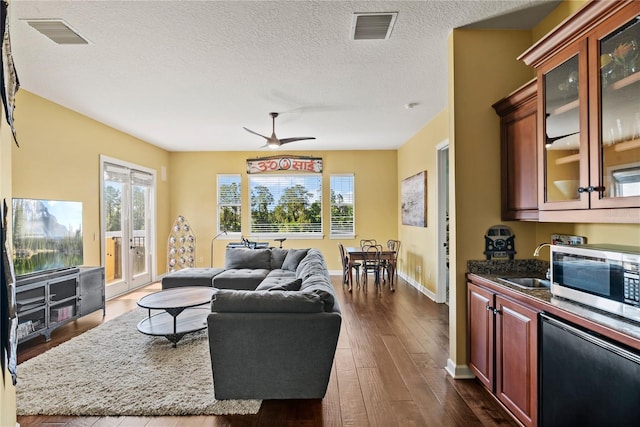 1070 Henley Downs Pl, Lake Mary, FL 32746 - living room featuring dark wood-style flooring, baseboards, a textured ceiling, and a ceiling fan