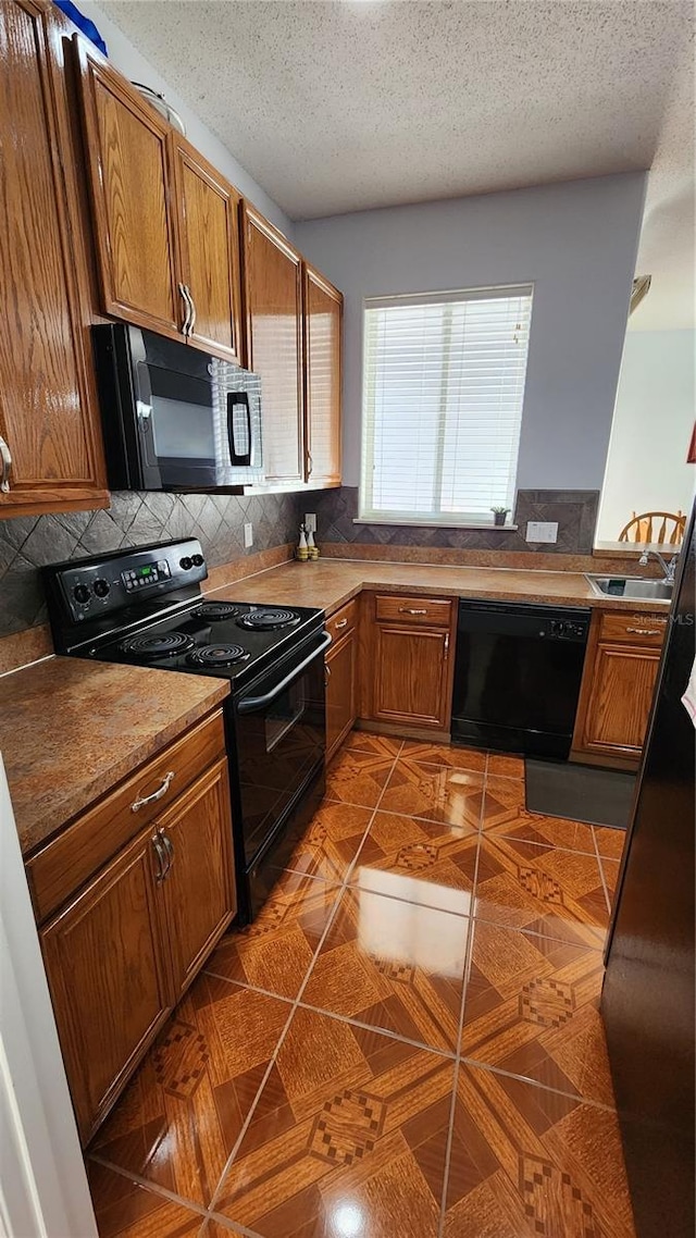 2157 Island Walk Dr, Orlando, FL 32824 - kitchen with black appliances, brown cabinets, decorative backsplash, and a textured ceiling
