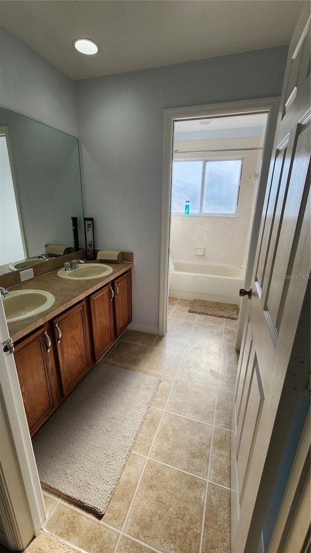 2157 Island Walk Dr, Orlando, FL 32824 - bathroom with double vanity, tile patterned floors, and washtub / shower combination