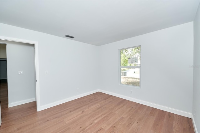 spare room featuring light wood-style flooring and baseboards