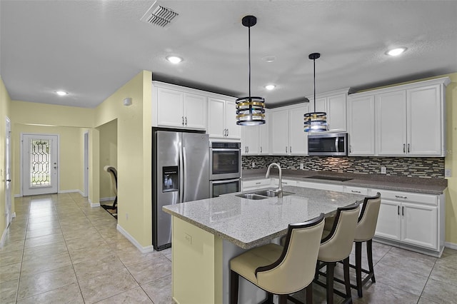 4051 Prairie Reserve Blvd, Orlando, FL 32824 - kitchen featuring stainless steel appliances, a sink, backsplash, white cabinets, and recessed lighting