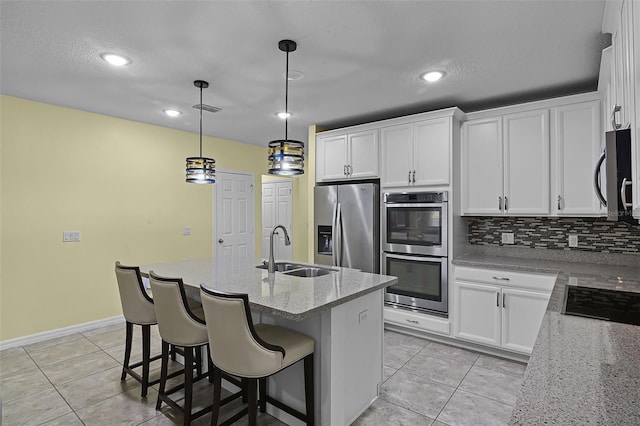 4051 Prairie Reserve Blvd, Orlando, FL 32824 - kitchen with a sink, stainless steel appliances, light tile patterned floors, decorative backsplash, and white cabinets