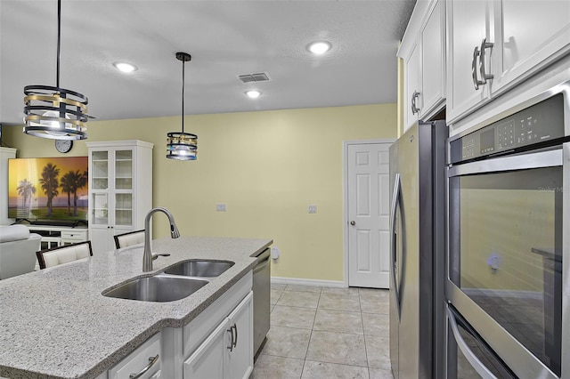 4051 Prairie Reserve Blvd, Orlando, FL 32824 - kitchen with a sink, appliances with stainless steel finishes, white cabinets, baseboards, and hanging light fixtures