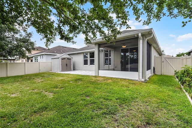 4051 Prairie Reserve Blvd, Orlando, FL 32824 - back of property featuring a storage shed, a sunroom, a gate, an outdoor structure, and a patio