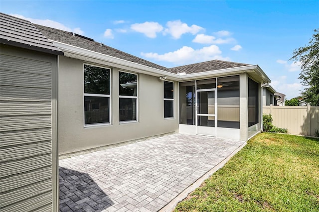 4051 Prairie Reserve Blvd, Orlando, FL 32824 - rear view of house featuring a sunroom, a patio area, a shingled roof, and stucco siding
