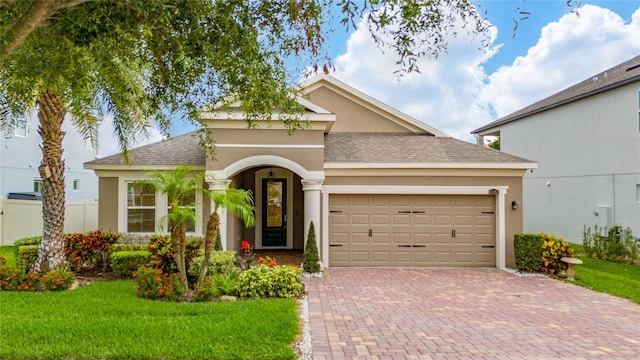 15862 Citrus Grove Loop, Winter Garden, FL 34787 - view of front of home with stucco siding, roof with shingles, a garage, and decorative driveway
