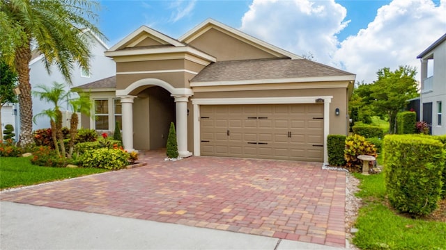 15862 Citrus Grove Loop, Winter Garden, FL 34787 - view of front of home with stucco siding, decorative driveway, a garage, and a shingled roof