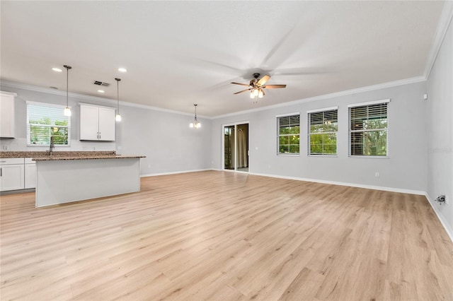 15862 Citrus Grove Loop, Winter Garden, FL 34787 - unfurnished living room featuring light wood-style floors, a ceiling fan, baseboards, ornamental molding, and a sink