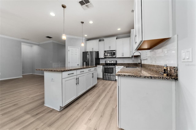 15862 Citrus Grove Loop, Winter Garden, FL 34787 - kitchen featuring stainless steel appliances, a sink, ornamental molding, light wood-style flooring, and a kitchen island
