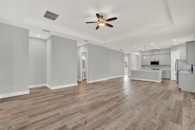 14826 Deaton Aly, Orlando, FL 32827 - unfurnished living room with a raised ceiling, a ceiling fan, light wood-style floors, recessed lighting, and crown molding