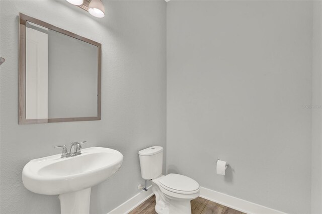 14826 Deaton Aly, Orlando, FL 32827 - half bathroom with wood finished floors, baseboards, a sink, and toilet