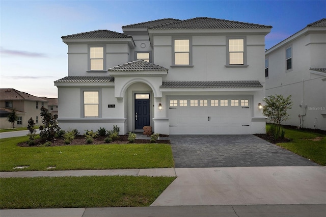 1575 Plunker Dr, Davenport, FL 33896 - mediterranean / spanish house featuring a tile roof, driveway, stucco siding, a front yard, and an attached garage