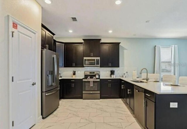 1575 Plunker Dr, Davenport, FL 33896 - kitchen with stainless steel appliances, light marble finish flooring, a peninsula, light countertops, and recessed lighting
