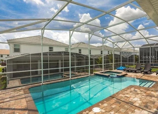 1575 Plunker Dr, Davenport, FL 33896 - view of swimming pool featuring a pool with connected hot tub, a patio area, and glass enclosure