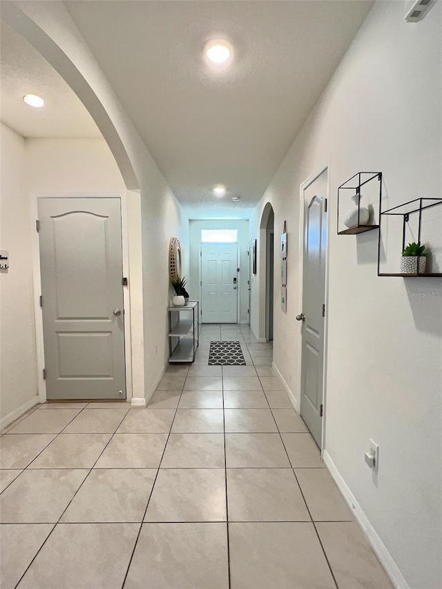 3329 Royal Tern Dr, Winter Haven, FL 33881 - hallway with light tile patterned floors, baseboards, and arched walkways
