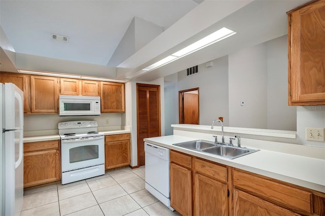 kitchen featuring white appliances, a sink, light countertops, and light tile patterned floors
