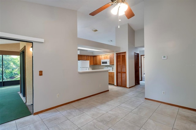unfurnished living room featuring high vaulted ceiling, a ceiling fan, baseboards, and light tile patterned floors