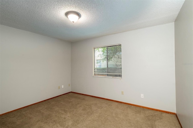 unfurnished room featuring a textured ceiling, light carpet, and baseboards
