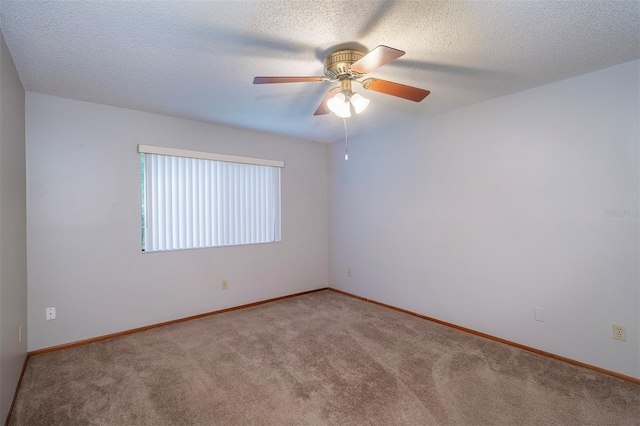 unfurnished room with carpet flooring, a ceiling fan, baseboards, and a textured ceiling