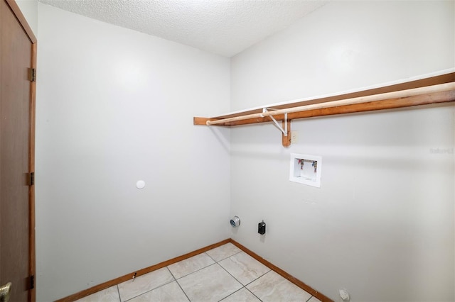 laundry room with washer hookup, light tile patterned flooring, baseboards, a textured ceiling, and hookup for a gas dryer