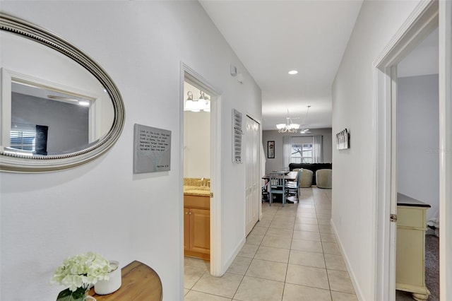 8919 Bismarck Palm Rd, Kissimmee, FL 34747 - corridor featuring light tile patterned floors, a sink, a chandelier, and baseboards