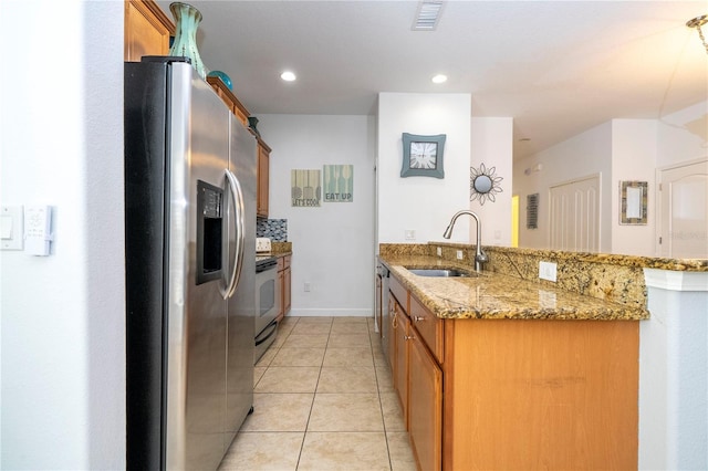 8919 Bismarck Palm Rd, Kissimmee, FL 34747 - kitchen with stainless steel refrigerator with ice dispenser, a sink, electric range oven, brown cabinets, and a peninsula
