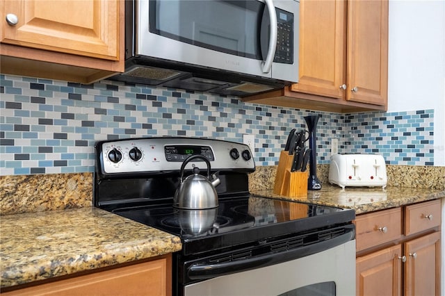 8919 Bismarck Palm Rd, Kissimmee, FL 34747 - kitchen featuring appliances with stainless steel finishes, backsplash, and light stone counters