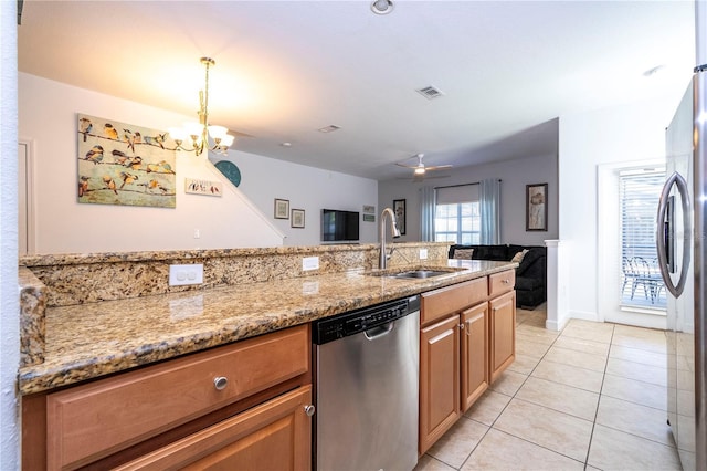 8919 Bismarck Palm Rd, Kissimmee, FL 34747 - kitchen featuring appliances with stainless steel finishes, a sink, light stone counters, light tile patterned floors, and a chandelier