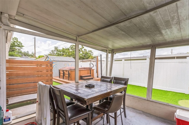 sunroom featuring outdoor dining area and a jacuzzi