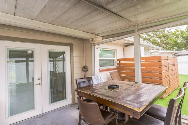 sunroom / solarium with french doors and outdoor dining area