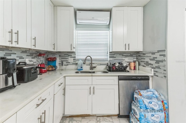 kitchen featuring dishwasher, an AC wall unit, a sink, and white cabinetry