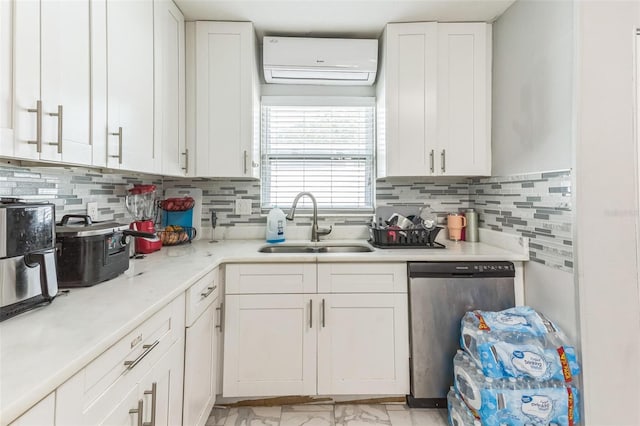 kitchen featuring dishwasher, an AC wall unit, a sink, white cabinets, and tasteful backsplash