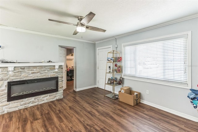 living area with ceiling fan, baseboards, crown molding, wood finished floors, and a fireplace