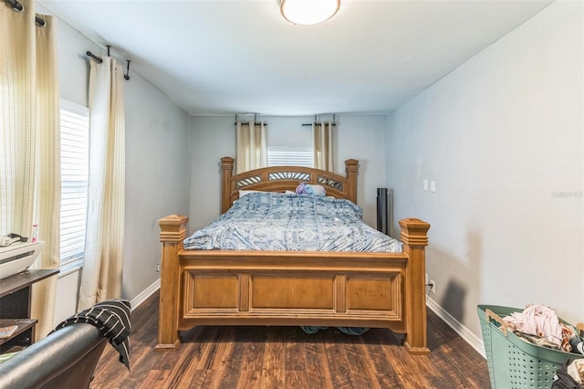 bedroom with dark wood finished floors, baseboards, and multiple windows