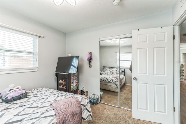 carpeted bedroom with a closet and multiple windows