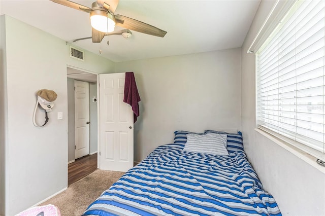 carpeted bedroom with multiple windows and ceiling fan