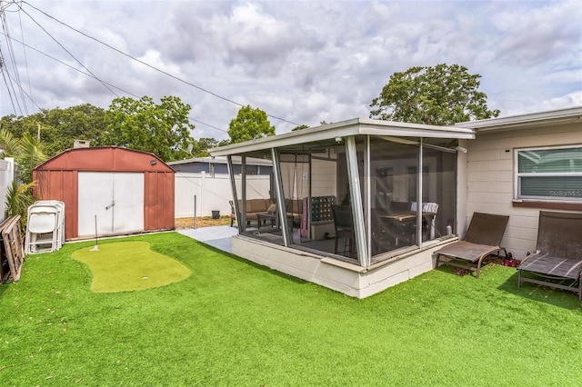 back of property with a sunroom, a putting area, a shed, an outbuilding, and a lawn