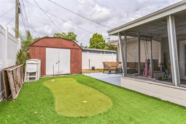fenced backyard with a patio, a putting green, a shed, an outdoor structure, and a sunroom