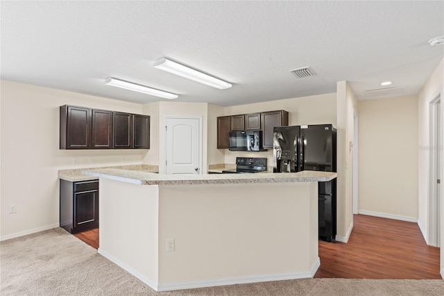 337 Southern Winds Blvd, Deland, FL 32720 - kitchen with black appliances, dark brown cabinetry, light countertops, a center island, and a textured ceiling