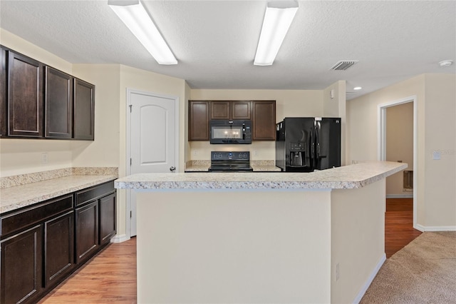 337 Southern Winds Blvd, Deland, FL 32720 - kitchen with black appliances, light countertops, dark brown cabinetry, a kitchen island, and a textured ceiling