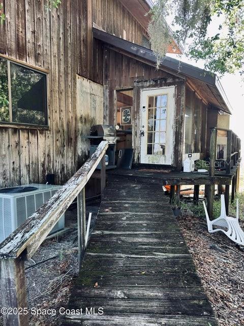 505 Lakeview Ave, Titusville, FL 32796 - view of exterior entry with a wooden deck and central AC unit