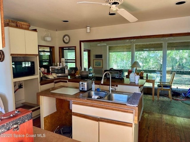 505 Lakeview Ave, Titusville, FL 32796 - kitchen featuring a sink, black microwave, ceiling fan, white cabinetry, and dark countertops