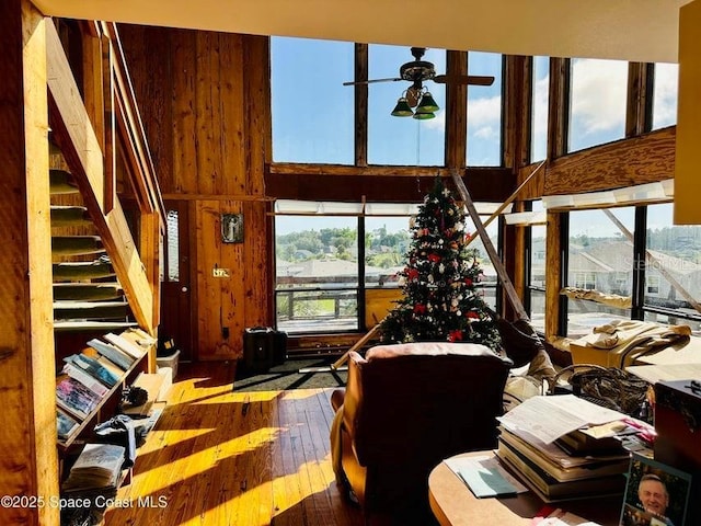 505 Lakeview Ave, Titusville, FL 32796 - living room with wood-type flooring, a ceiling fan, a high ceiling, stairway, and wood walls