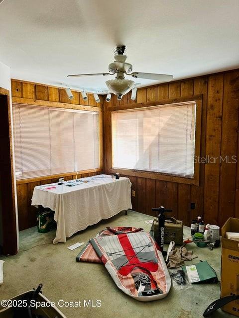 505 Lakeview Ave, Titusville, FL 32796 - bedroom featuring wooden walls, carpet flooring, and ceiling fan