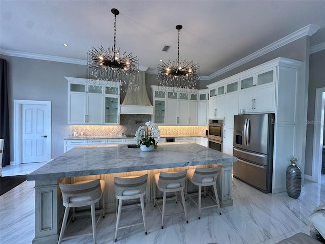 kitchen with appliances with stainless steel finishes, a chandelier, crown molding, backsplash, and a large island